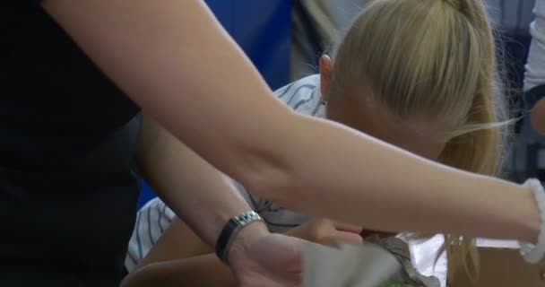 Nauczyciel pomaga kobietę nastoletnia blondynka do malowania dzieci malowania katedry na aukcję charytatywną — Wideo stockowe