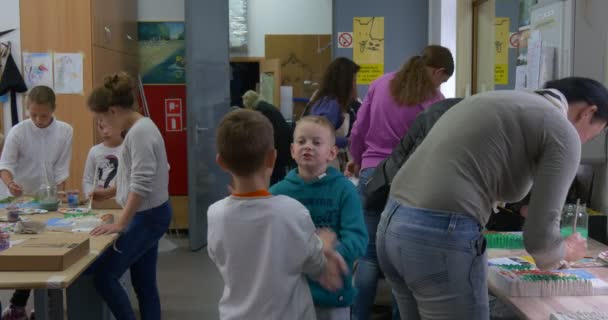 Grupo de niños adolescentes y maestros adultos jóvenes en el taller Los niños están pintando Catedral polaca para la subasta de caridad Títeres Teatro de actores — Vídeo de stock