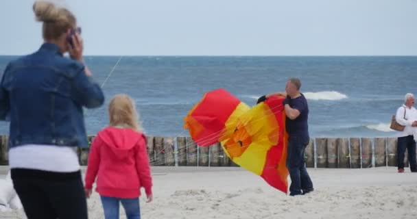 Starten van een parachute-achtige kite - mensen voorbereiding van hun vliegers en Air zwemmers of vliegen ze op de internationale kite festival in Łeba, Polen. — Stockvideo