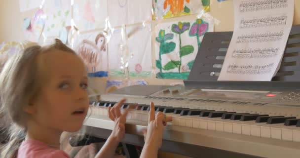 Baby Girl tocando no teclado eletrônico de piano com entusiasmo — Vídeo de Stock