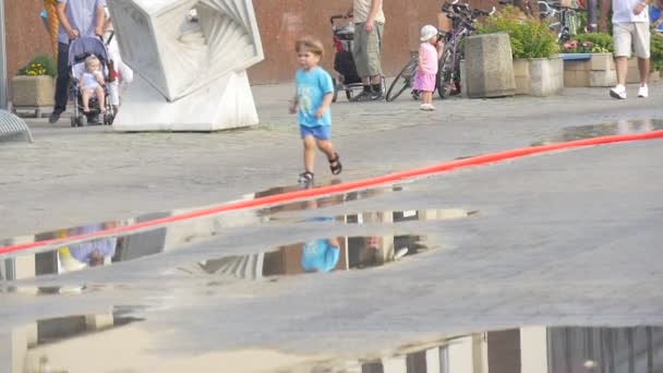 Il ragazzo vestito con una t-shirt blu e un pantaloncino blu corre lungo la strada . — Video Stock