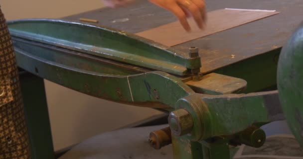 Les mains de l'homme coupent la plaque de cuivre dans la guillotine Installation de la plaque de cuivre à la machine Préparer la plaque de cuivre pour l'atelier d'artisanat de gravure — Video