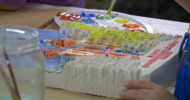 Mano de niño con pincel Pintura amarilla Los niños están pintando la catedral para la subasta de caridad Títeres y teatro de actores — Vídeo de stock