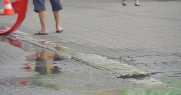 De kleine jongen met een glimlach op het gezicht speelt in een plas — Stockvideo