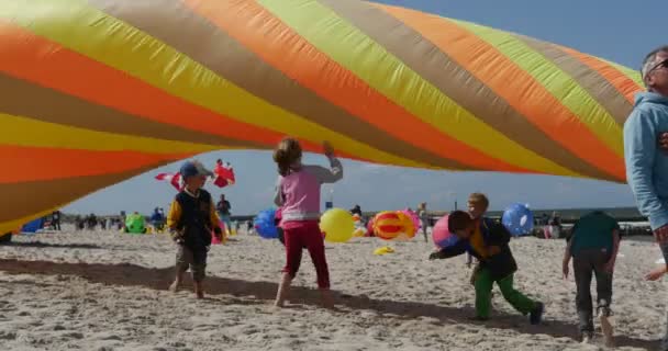 Děti od kónické vzduchu plavec - lidé připravuje jejich draky a vzduchu plavci nebo létání na mezinárodní kite festival v Leba, Polsko. — Stock video