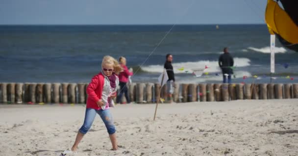 Mensen beginnen hun vliegers - mensen voorbereiding van hun vliegers en Air zwemmers of vliegen ze op de internationale kite festival in Łeba, Polen. — Stockvideo