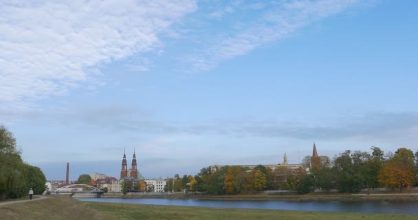 Man is Walking by Footpath in Park at Odra River Roman Catholic Parish of the Holy Cross Cathedral at the Odra Landscape Buildings on a Horizon — Stock Video