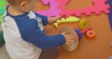 Küçük çocuk ve bir oyuncak Piramyd indir katlı tarama uzak oynarken üzerinde plastik bir oyuncak Oluşturucu Merkez Kütüphanesi'nde oturmuş, bir