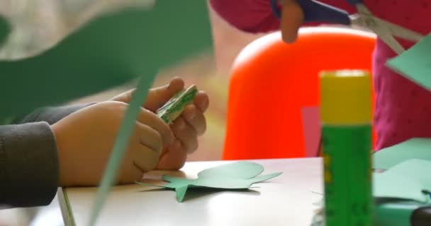 Gyerekek dolgoznak színes papír gyerekes Hands ragasztó készítése könyv Toy tanár segíti a gyermekek központi könyvtár műhely játékok létrehozása — Stock videók