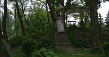 Onun saç gevşek aşağıda yavaş yavaş geri gelinler Parade yürüyüş çadır altından yürüme ile kırmızı uzun kemer gelin ile beyaz kılıf içinde gelin kadın