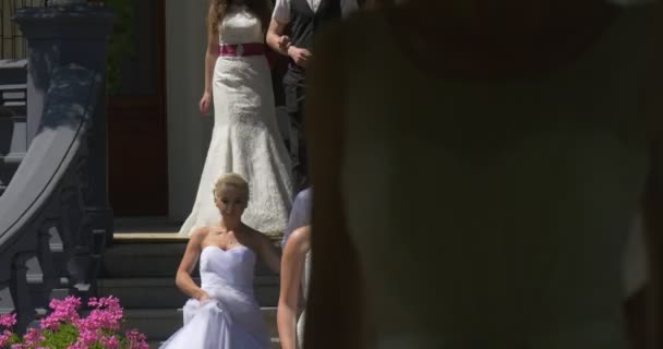 Brides Group of Women marche en bas vers la caméra Femmes en robes blanches Hommes en costumes Brides Parade in Green Park Ancien bâtiment vintage — Video