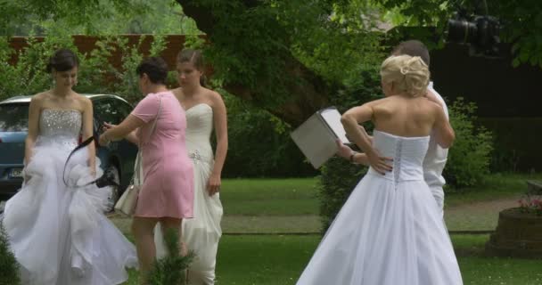 妇女在白色礼服新娘和男人相机船员人民与相机彩排新娘游行在公园人都看着平板电脑屏幕照相机上站 — 图库视频影像
