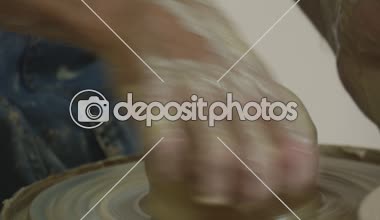 Potter usta kot önlük teknesi başparmak kirli eller yakın yukarı çanak çömlek Atölyesi tarafından içine bir kil Pot kavite yapma çanak çömlek çarkı döküm üzerinde çalışıyor