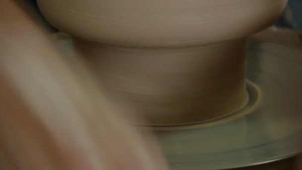 Поттер Майстер працює над гончарним колесом формуючи нижню частину глиняного горщика роблячи посудину брудними руками Близько колеса зупиняється знову гончарна майстерня — стокове відео