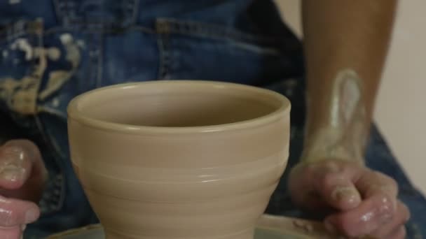 Potter Craftsman is Teaching a Student Working on Pottery Wheel Shows How to Mould a Clay Pot Making a Vessel Dirty Hands Close Up Pottery Workshop — Stock Video