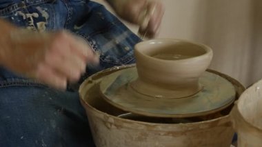 Potter usta bir ıslak Pot dışında seramik tekerlek ayırarak konu adam değil bir kil Pot eller yakın yukarı çanak çömlek Atölyesi kalıp için son alıyor