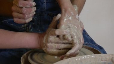 Potter öğrenci usta bir kil Pot kadın öğretmen çanak çömlek çarkı döküm üzerinde çalışıyor onun eller yardımcı Holding adam kirli eller seramik kurs olmasıdır