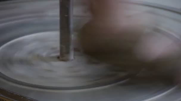 Man Potter 's Foot in Sandal is Rotating a Pottery Wheel Craftsman is Working on the Wheel Moulding a Clay Pot Making a Vessel Oficina de cerâmica — Vídeo de Stock