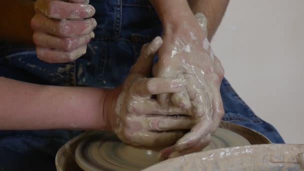 Potter Student Craftsman is Working on Pottery Wheel Moulding a Clay Pot Female Teacher is Holding His Hands Helps the Man Dirty Hands Pottery Workshop — Stock Video