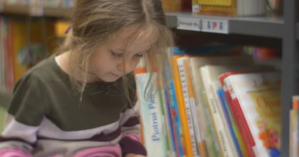 Das Mädchen liest das interessante Buch — Stockvideo