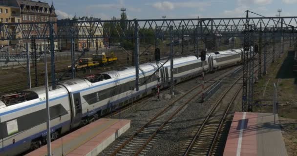 Moderní osobní vlak je že přesun z The Platphorm v budově železničního nádraží železnice s drátem věže žlutá lokomotiva je stojící Opole, Polsko — Stock video