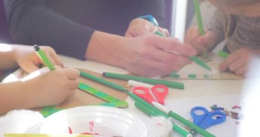 Çocuklar ve Eğitimci Bir Üçgen Yeşil Marker Payetler ve Makas Boyama bir Masa Eller Close Up İnsanlar Masa Boyama oturuyor