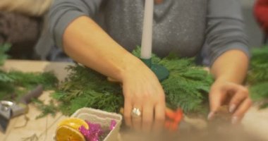 Kadın bir kesme makineleri için kesme koni kullanıyor ve Noel kompozisyon, Advent çelenk dalları oturup tablo yeni yıl Master Class ekleyin