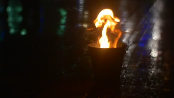 양동이 혀에 불이 댄서를 올리고 있다 화재 사람들의 다리 그림자 포장 광장 다채로운 조명 화재 쇼 저녁 슬로우 모션 — 비디오