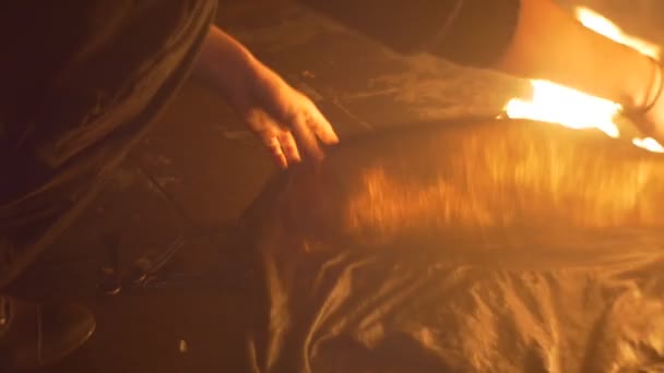 L'homme éteint un feu par le tissu humide Torche lentement le feu accessoires nécessaires de troupe de danse après avoir effectué une danse du feu au spectacle de feu Soirée 