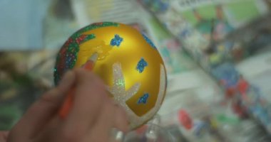 Anne Eli Noel Ball bir Glitter Çocuksu El koymak için bir Tutkal koyarak bir Top üzerinde başka bir yere işaret ediyor orada bir Tutkal koymak isteyen