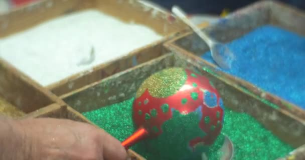 As pessoas estão derramando azul verde branco Glitter pó para suas bolas de Natal por colheres segurando-os em um punho família Master Class em Opole Biblioteca — Vídeo de Stock