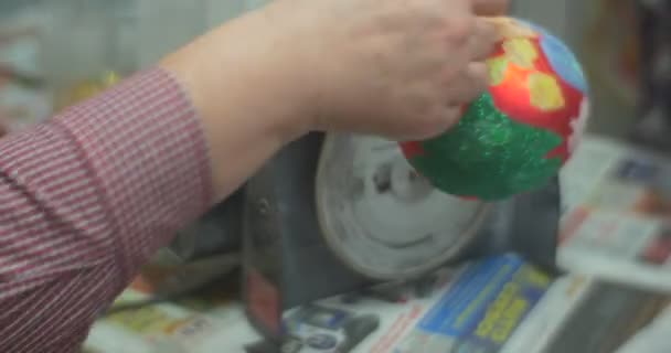 El hombre rojo de la bola de Navidad está aserrando un juguete de la manija usando una máquina que muele La bola de Navidad se está preparando para una persona que lo hizo en la clase maestra de la familia — Vídeos de Stock