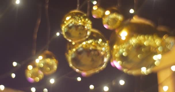 Bolas decorativas Golder Chtistmas de oro juguetes colgando de una lámpara de cable Guirnaldas Decoración de una plaza de Sofía Celebración de Año Nuevo Kiev Ucrania — Vídeos de Stock