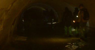 İnsanlar ile baş ışıklar içinde tünel adam ışıklar yolu erkek ve kadın sırt çantaları grup insan ile bir Kiev mağaralara gezisi, yürüyüş olduğunu