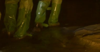 Gumboots İnsanlar Bir Mağara Yeraltı Nehri İnsanlar Işık Lambalar Kırmızı Ceketli Dikkatle Adam Wading tarafından Yol Yürüyüş Gumboots İnsanlar