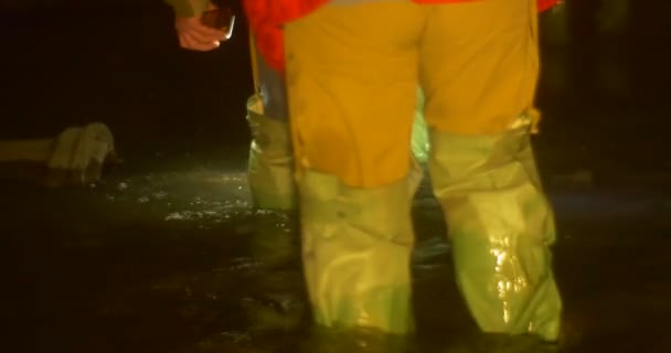 Touristen betrachten das alte Rohr in einem Fluss Männer waten durch Wasser in einer Höhle Touristen gehen vorsichtig und erkunden einen unterirdischen Fluss — Stockvideo