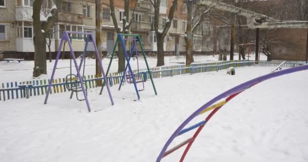 Deux balançoires balancent l'équipement de terrain de jeu de bac à sable couvert de neige Aire de jeux pour enfants sans enfants dans les maisons résidentielles d'hiver Une grande partie de la neige — Video