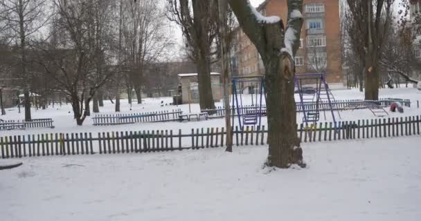 Panorama de un patio Balanceo Escaleras Parque infantil Cubierto de nieve Parque infantil sin niños en invierno Casas Residenciales Mucha nieve — Vídeos de Stock