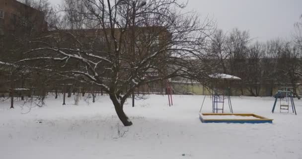 Havrani na Sněžné dětské hřištní vybavení pokryté sněhovou dětským hřištěm bez dětí v zimě překryté domy velká část sněhu — Stock video