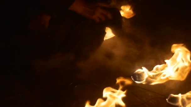 Les mains des hommes éteignent le feu La fumée fait monter le feu sur un feu au sol Les torches brûlent au ralenti Le feu orange brûle dans l'obscurité En plein air Nuit 