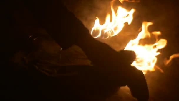 Les mains masculines éteignent un feu Mouvement lent éteint par morceau de tissu Les torches de feu brûlent la fumée de flamme orange augmente la nuit à l'extérieur 