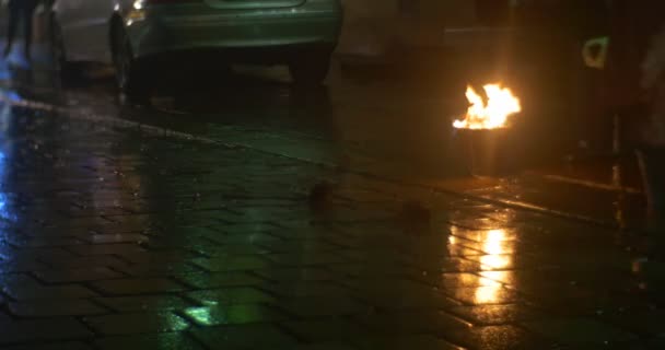 El fuego de las sombras del pueblo arde en un cubo al aire libre Peson toma un camino de cubo pavimentado por piedras El fuego se apaga Las antorchas arden la noche — Vídeo de stock