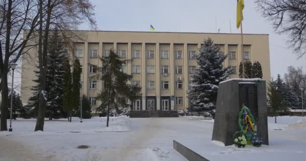Edifício Administrativo da Bandeira Ucraniana da Cidade de Konotop está acenando no local onde as Wreathes do enterro do antigo Lenin Memorial são colocadas em uma bandeira — Vídeo de Stock