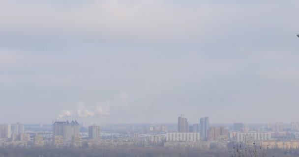 Stadtbild eines Dniper-Flusses am linken Ufer in winterlichen Gebäuden eines Tröschina-Bezirks in Kiev am Horizont steigt Rauch aus einem röhrengrauen Himmel auf. — Stockvideo