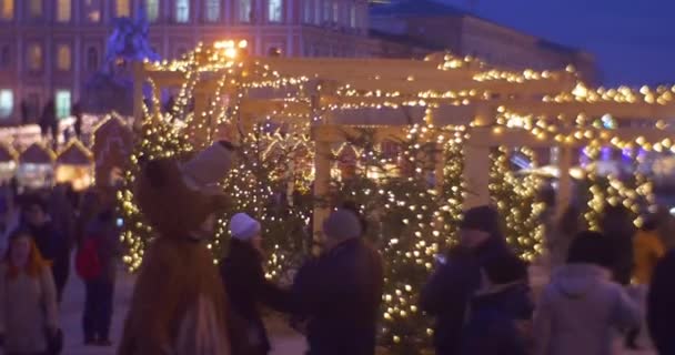 Animateur en costumes d'ours Les gens marchent ruelle d'un petit sapin décoré avec des guirlandes de lampe Foire de Noël Place Sofia Célébration du Nouvel An Kiev — Video