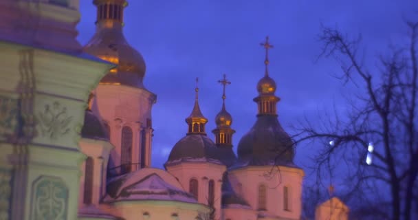 Bâtiments d'une cathédrale de Sofia Branches nues Arbres décorés avec des lumières de lampe bleue Dômes d'or à Sofia Square Ciel bleu foncé Nouvel An Kiev Ukraine — Video