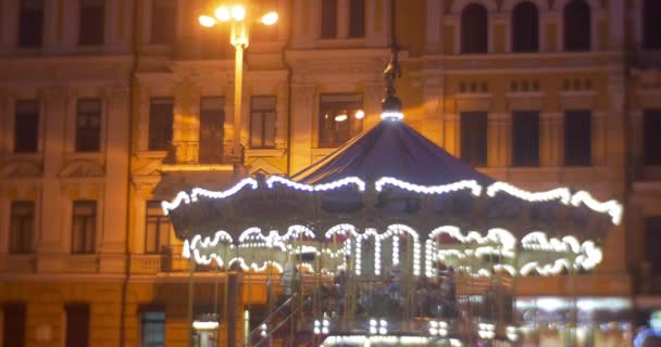 Az emberek sétálnak körül a karácsonyi körhinta hegymászás egy körhinta karácsonyi vásár a Szófia tér kivilágított utcai újévi ünnep Kiev — Stock videók