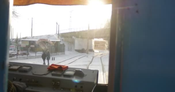 Вид кабіни трамвая, що знаходиться на трамваї від трамвайної зупинки трамвая, проїжджаючи під мостом автомобілі, що знаходяться на залізниці в Конотопській міській — стокове відео