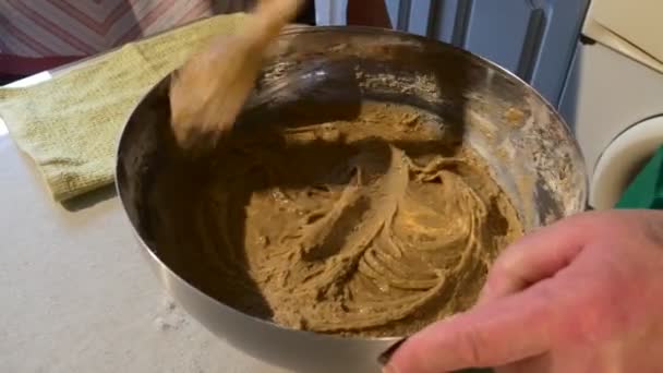 Männliche Hände in Großaufnahme kneten einen braunen Teig Ehemann und Frau in der Küche machen einen Teig für ein Gebäck Kuchen Leute kochen am Tisch — Stockvideo