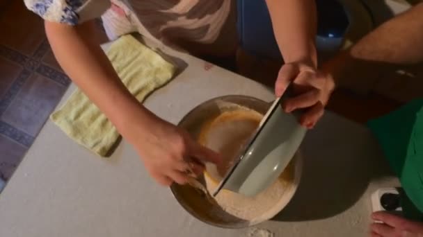 Femme verse farine homme tient un tamis tamise une farine mari et femme à la cuisine font une pâte pour un biscuit cuisson à la table — Video